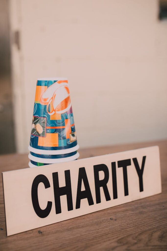 Stacked paper cups and a charity sign symbolizing donations and giving back.